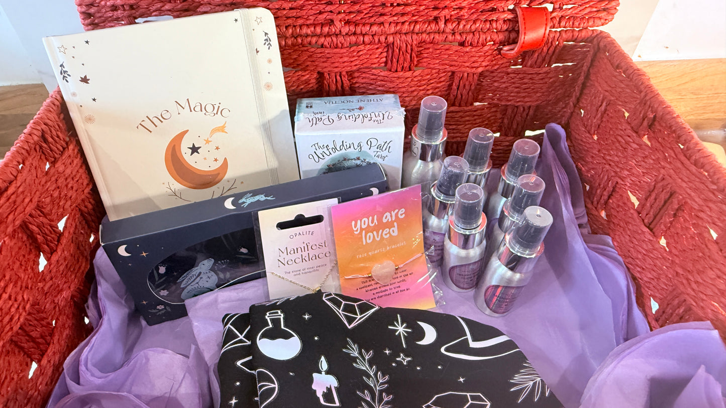 Gift basket with various items including books and bottles on a textured surface