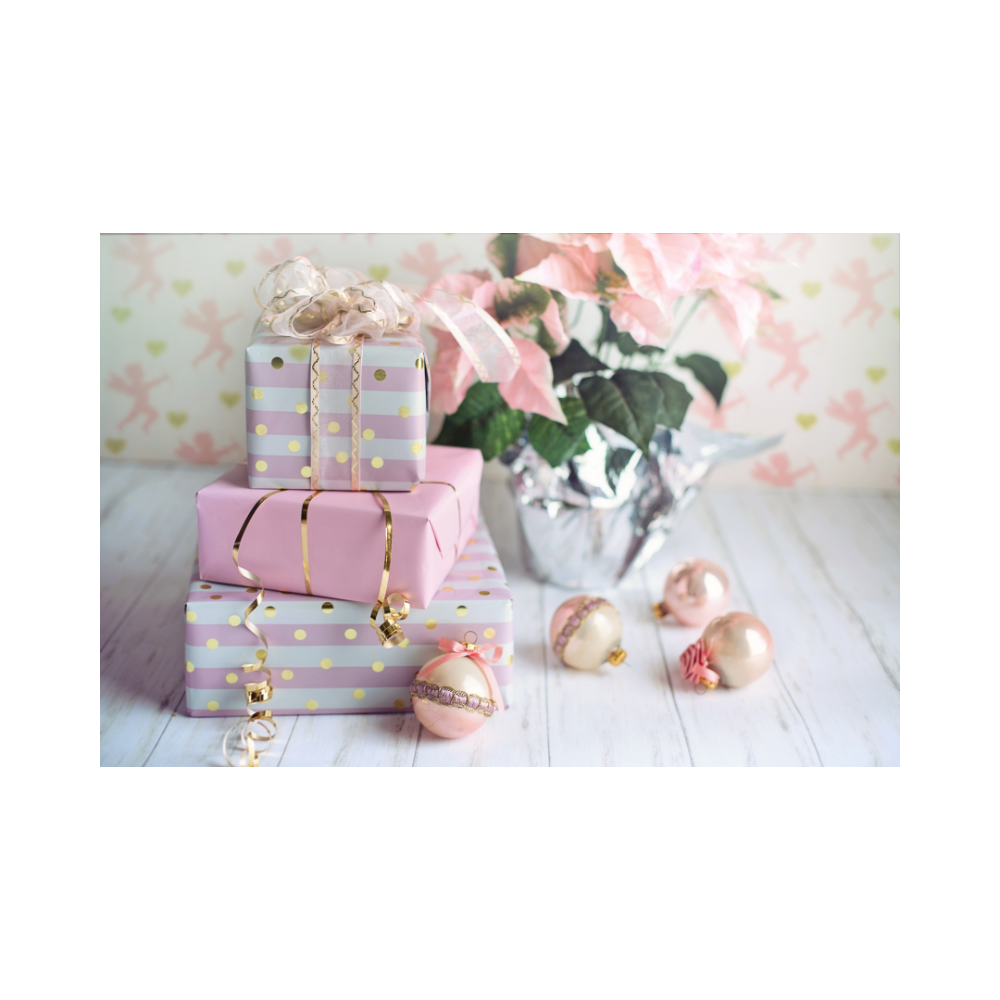 A pile of christmas presents wrapped up with a few baubles by them along with a plant in the background