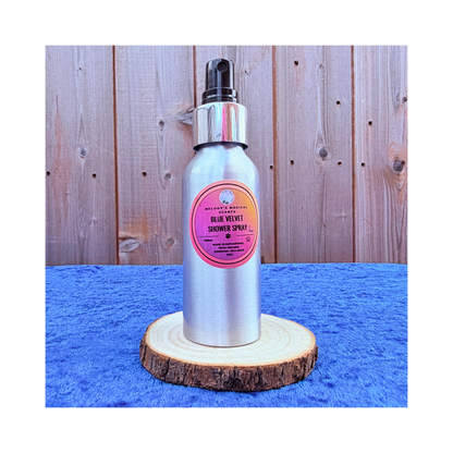 Silver shower spray bottle with pink label on a wooden stand against a wooden background