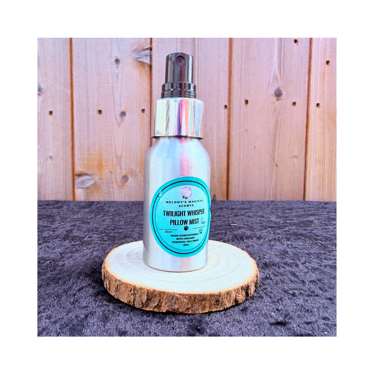 Silver spray bottle with a blue label on a wooden stand against a wooden panel background